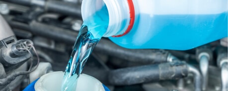 Pouring anti-freeze into car